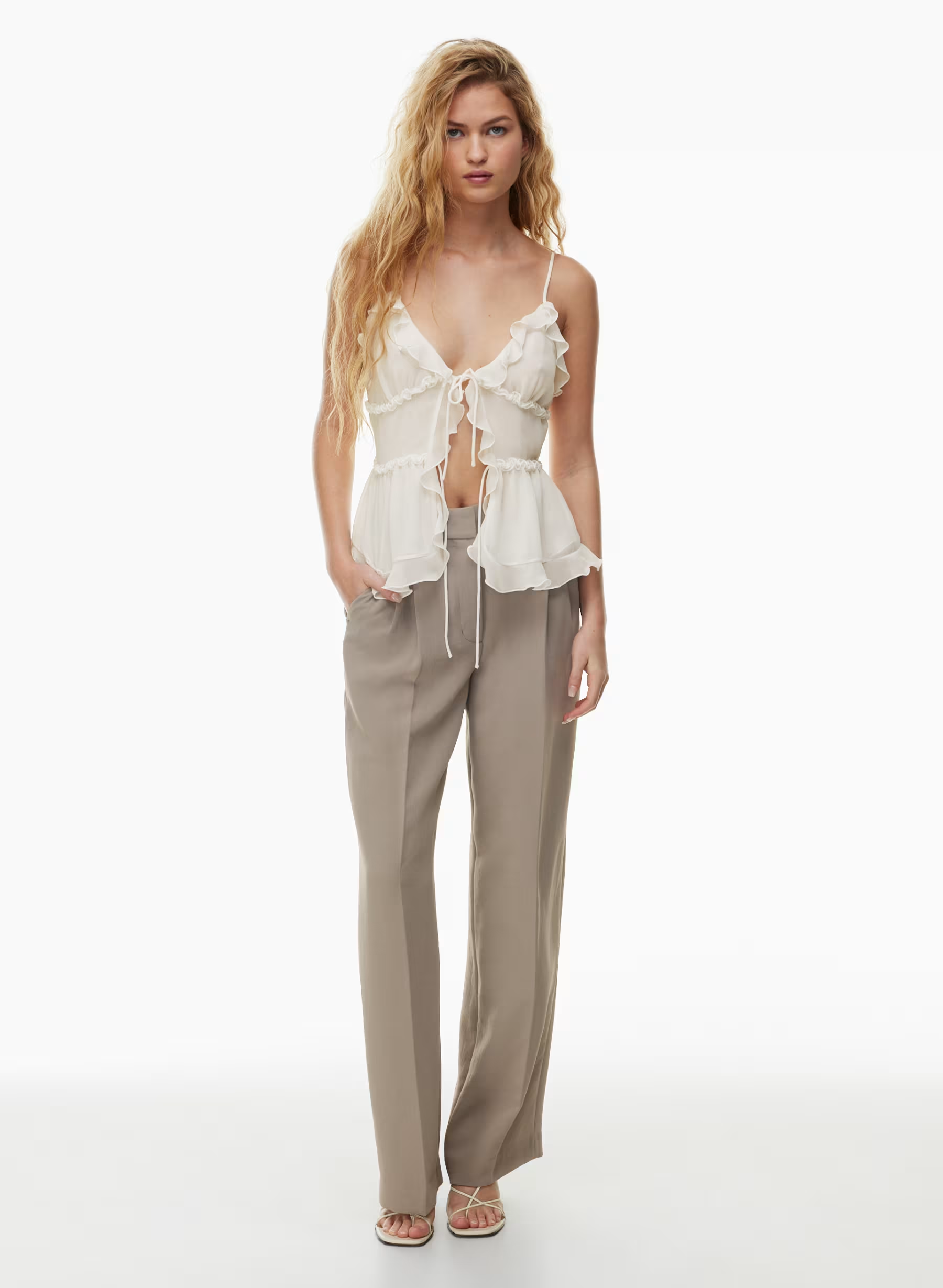 Flowy white ruffled top paired with beige Aritzia Effortless Pant